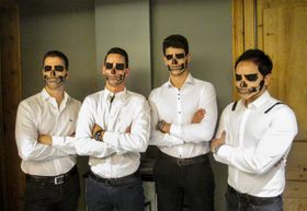 Cuatro caras pintadas de calavera, con las cuencas de los ojos en negro y la dentadura dibujada sobre los labios
